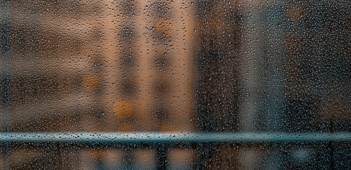 Gotas de água se acumulam em vidraça com prédios desfocados ao fundo. Umidade é um perigo para obras de arte porque favorece surgimento de fungos e mofo.